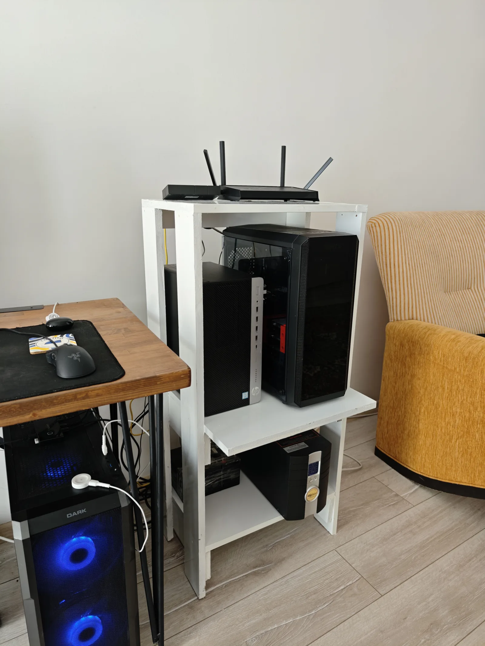 The finished modular wooden homelab rack with 1 kVA UPS on the bottom, two Proxmox compute towers in the middle, and networking gear on top